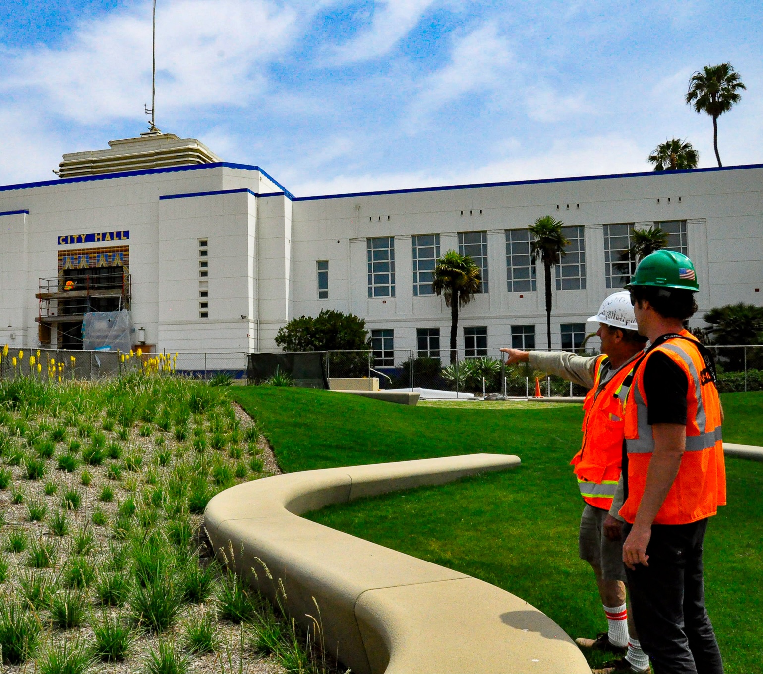 Two workers survey newly installed grasses.